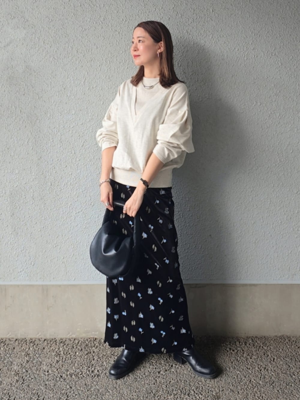 ベージュ系のTシャツ/カットソー、ブラック系のスカート、ブラック系のパンプスを着用したレディースの春コーディネートの2枚目の写真