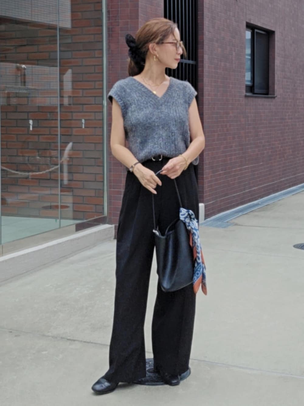 グレー系のベスト、ブラック系のスラックスを着用したレディースの秋コーディネートの2枚目の写真
