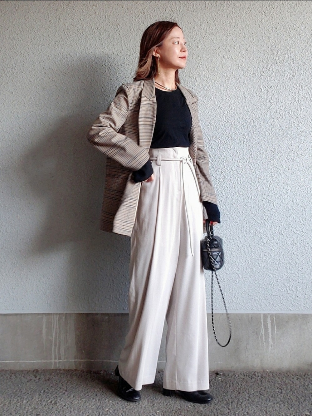 ホワイト系のその他パンツ、ブラック系のブーツ、ブラック系のバッグを着用したレディースの冬コーディネートの3枚目の写真