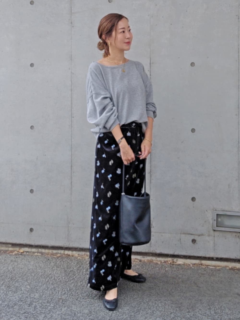 グレー系のスウェット、ブラック系のスカート、ブラック系のパンプスを着用したレディースの秋コーディネートの3枚目の写真