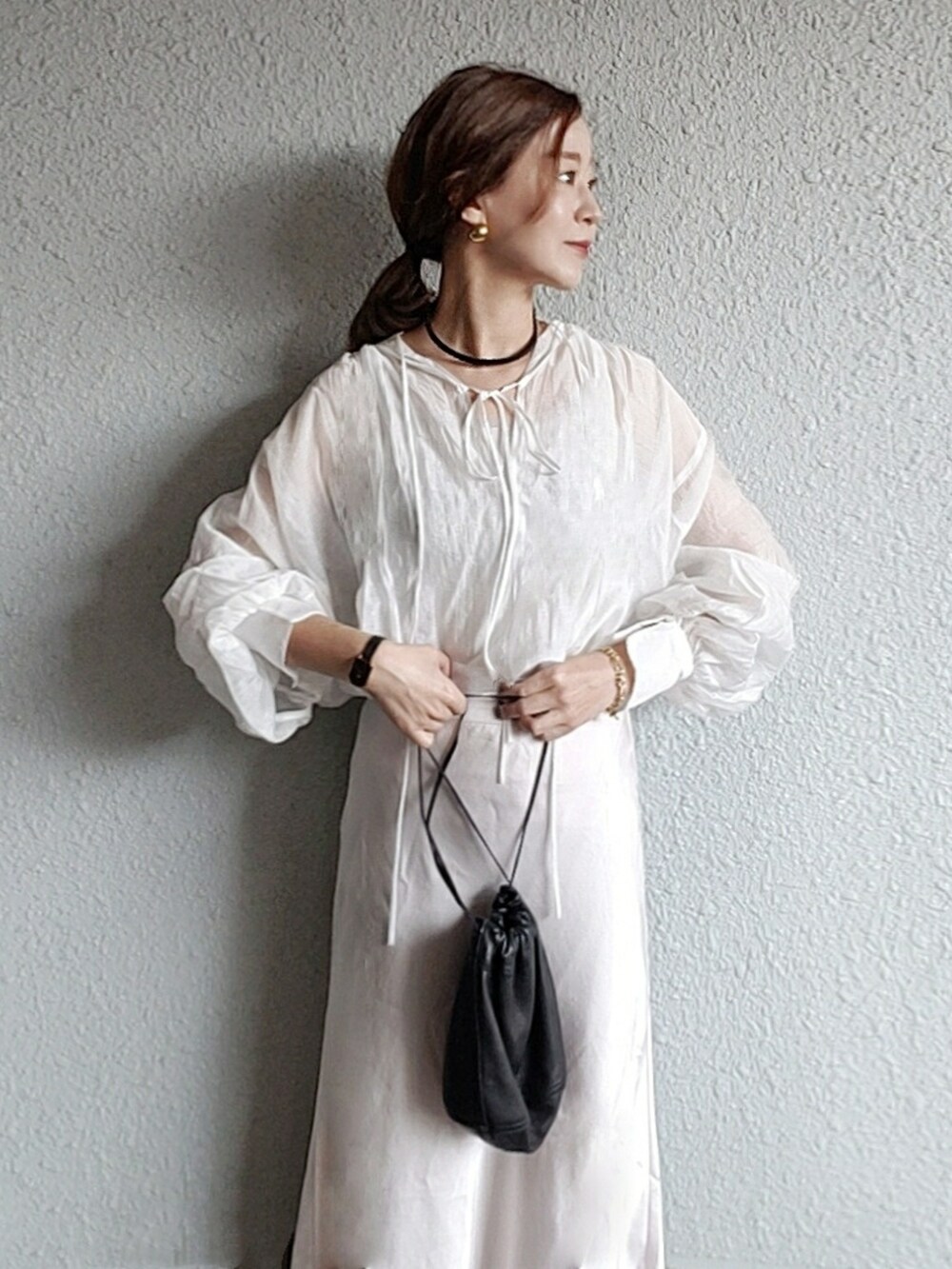 ブラック系のバッグ、ブラック系のバレエシューズ、ホワイト系のスカートを着用したレディースの春コーディネートの2枚目の写真