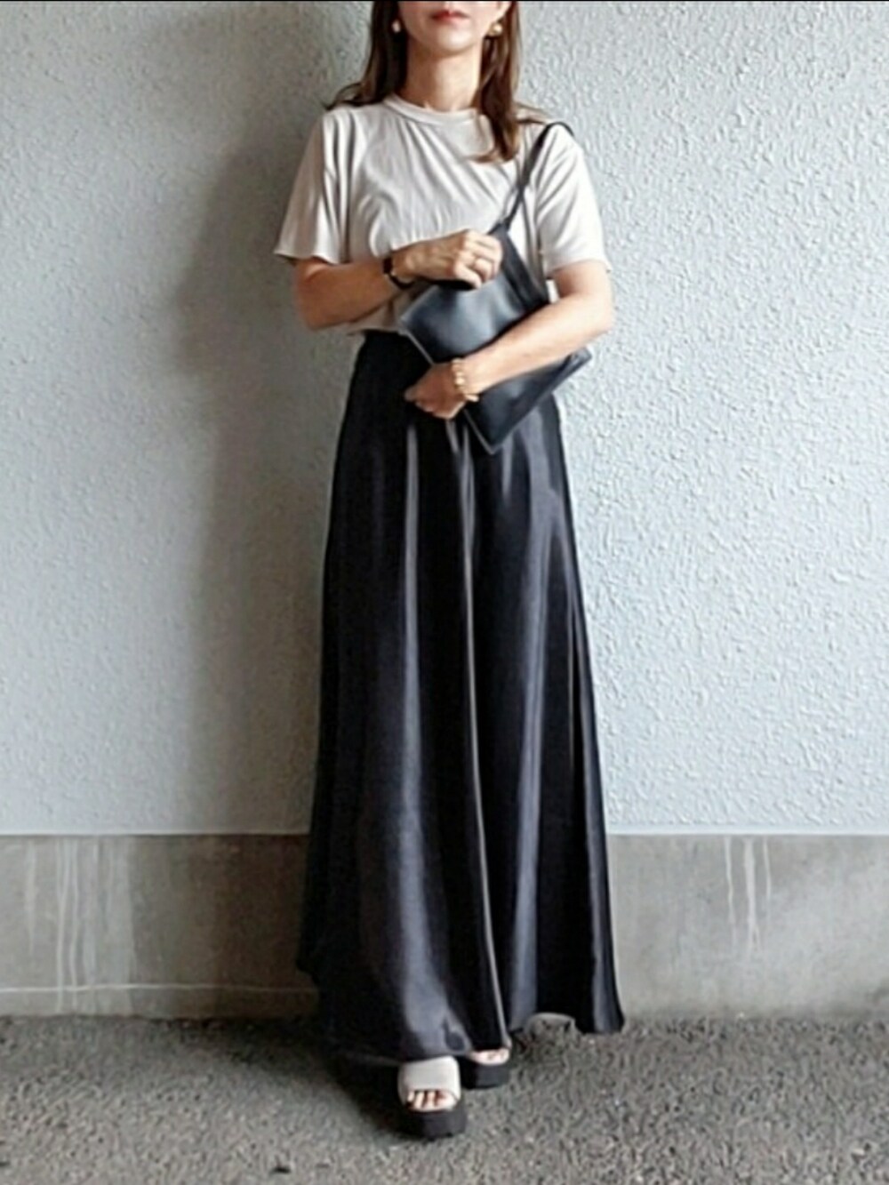 グレー系のTシャツ/カットソー、ブラック系のスカート、グレー系のサンダルを着用したレディースの秋コーディネートの4枚目の写真