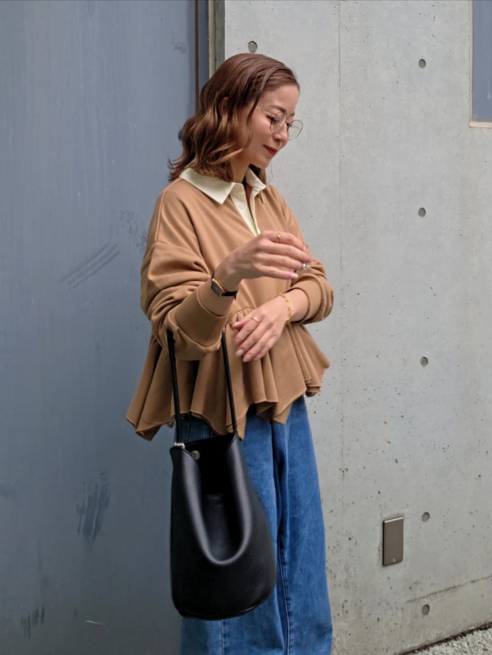 イエロー系のスウェット、ブルー系のデニムパンツ、ブラック系のパンプスを着用したレディースの春コーディネートの4枚目の写真