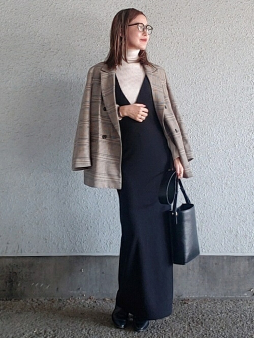 ブラック系のワンピース、ブラック系のブーツ、ブルー系のテーラードジャケットを着用したレディースの冬コーディネートの2枚目の写真