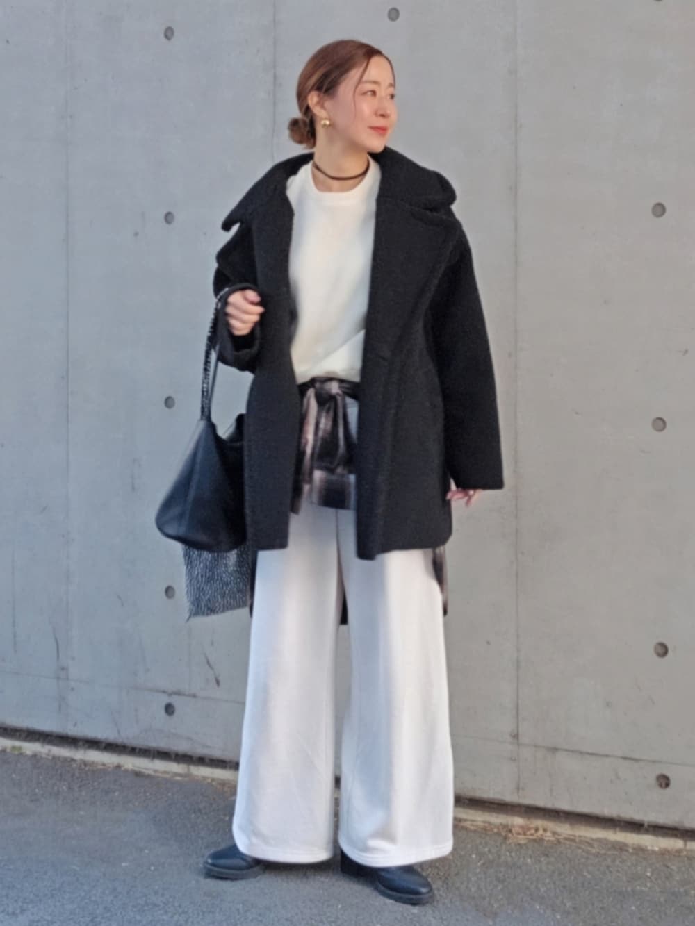 ブラック系のムートンコート、ホワイト系のニット/セーター、ブラック系のシャツ/ブラウスを着用したレディースの冬コーディネートの2枚目の写真