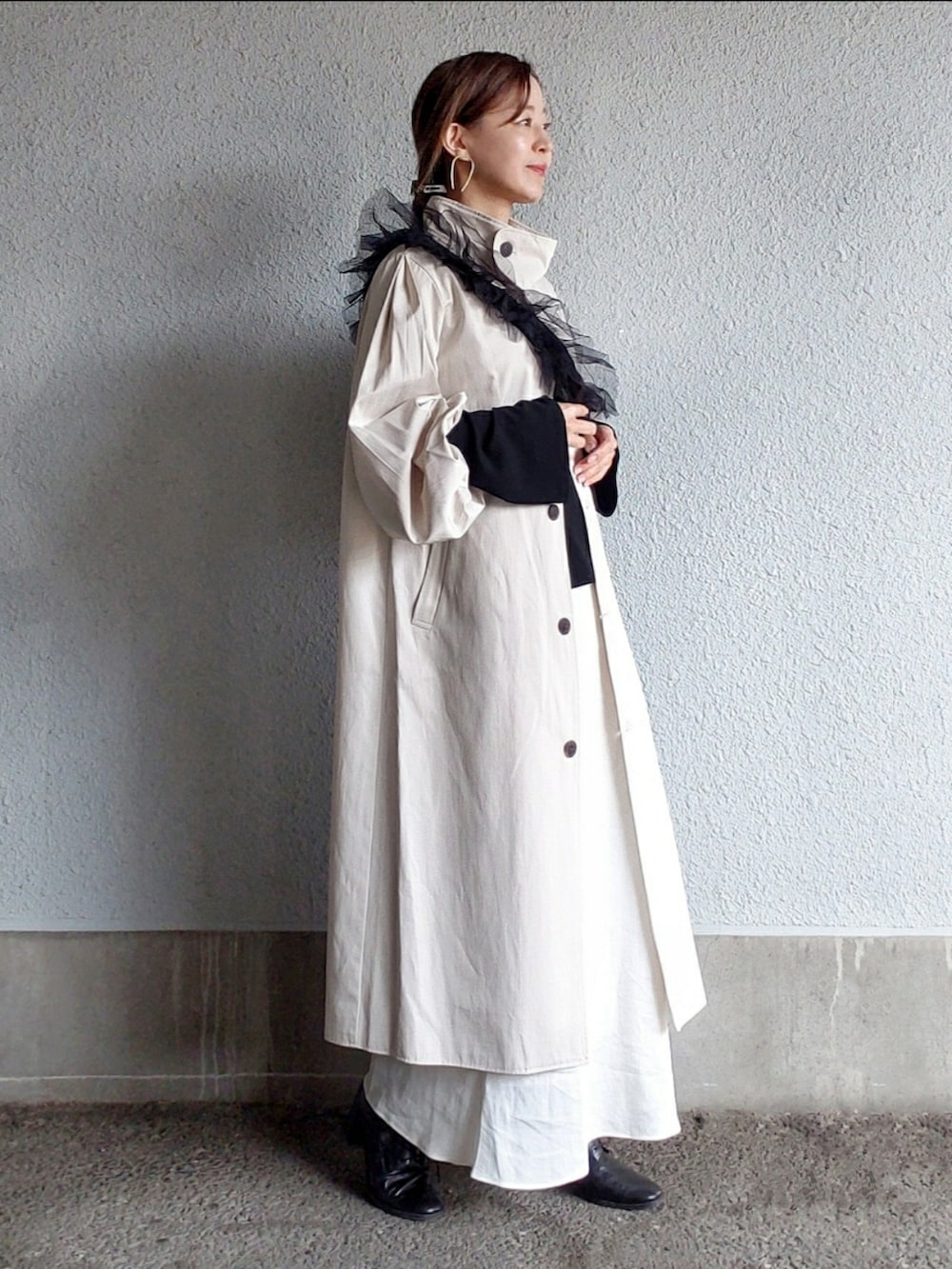 ホワイト系のトレンチコート、ホワイト系のスカート、ブラック系のTシャツ/カットソーを着用したレディースの冬コーディネートの2枚目の写真
