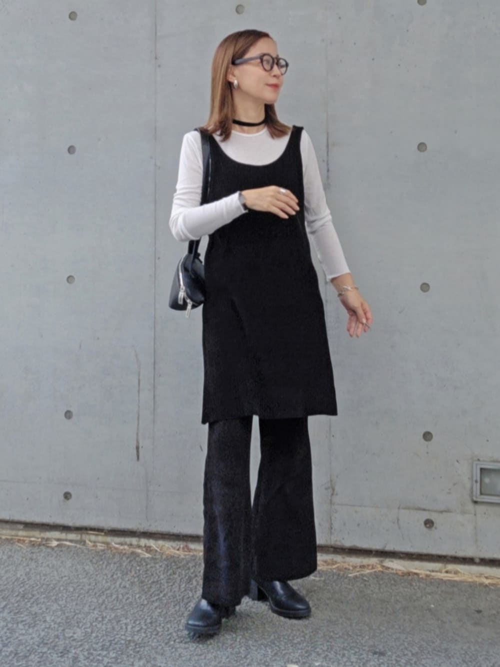 ブラック系のワンピース、ブラック系のパンツ、ブラック系のブーツを着用したレディースの秋コーディネートの2枚目の写真