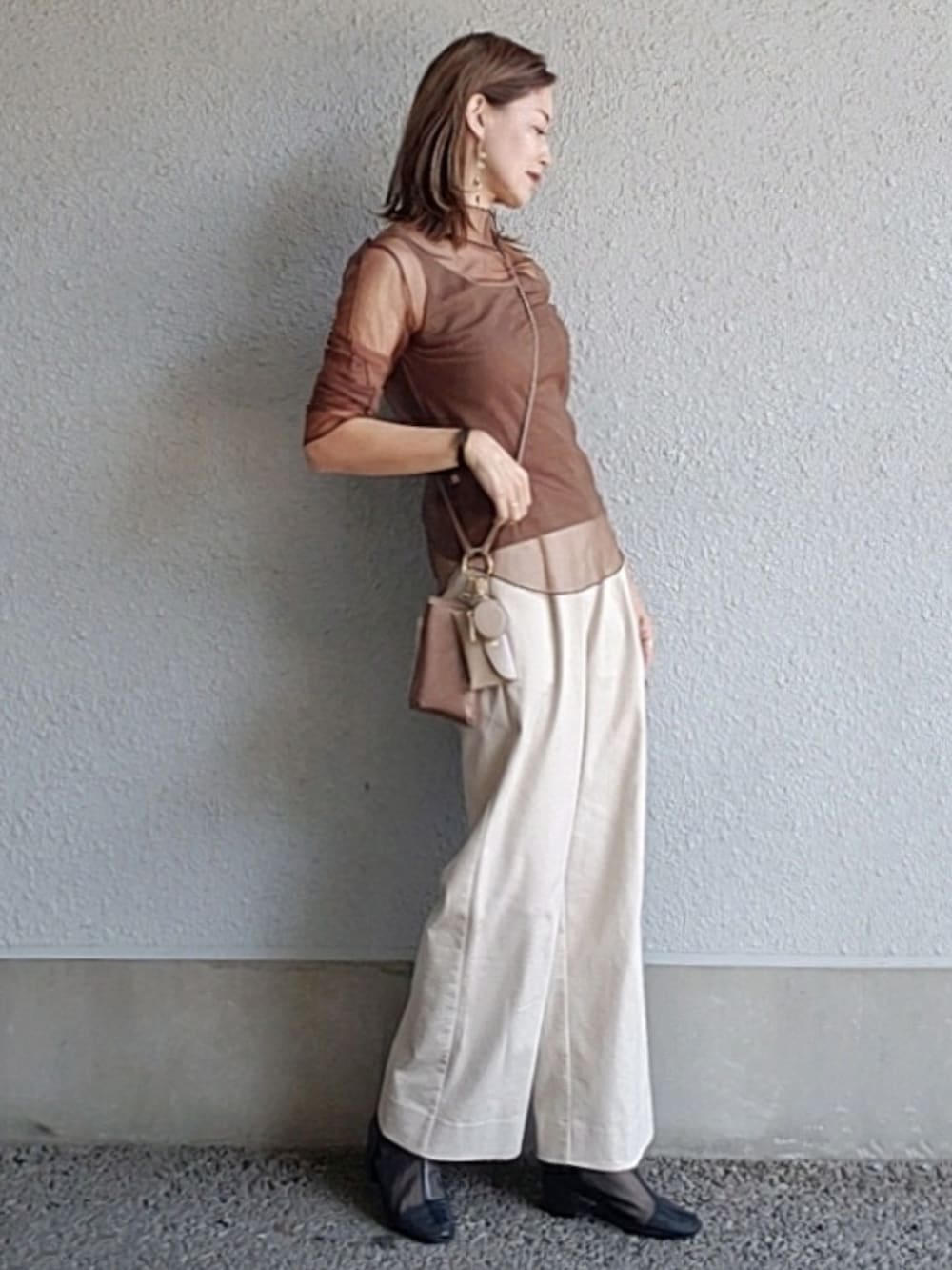 ブラウン系のショルダーバッグ、ベージュ系のその他パンツ、ブラウン系のTシャツ/カットソーを着用したレディースの秋コーディネートの2枚目の写真