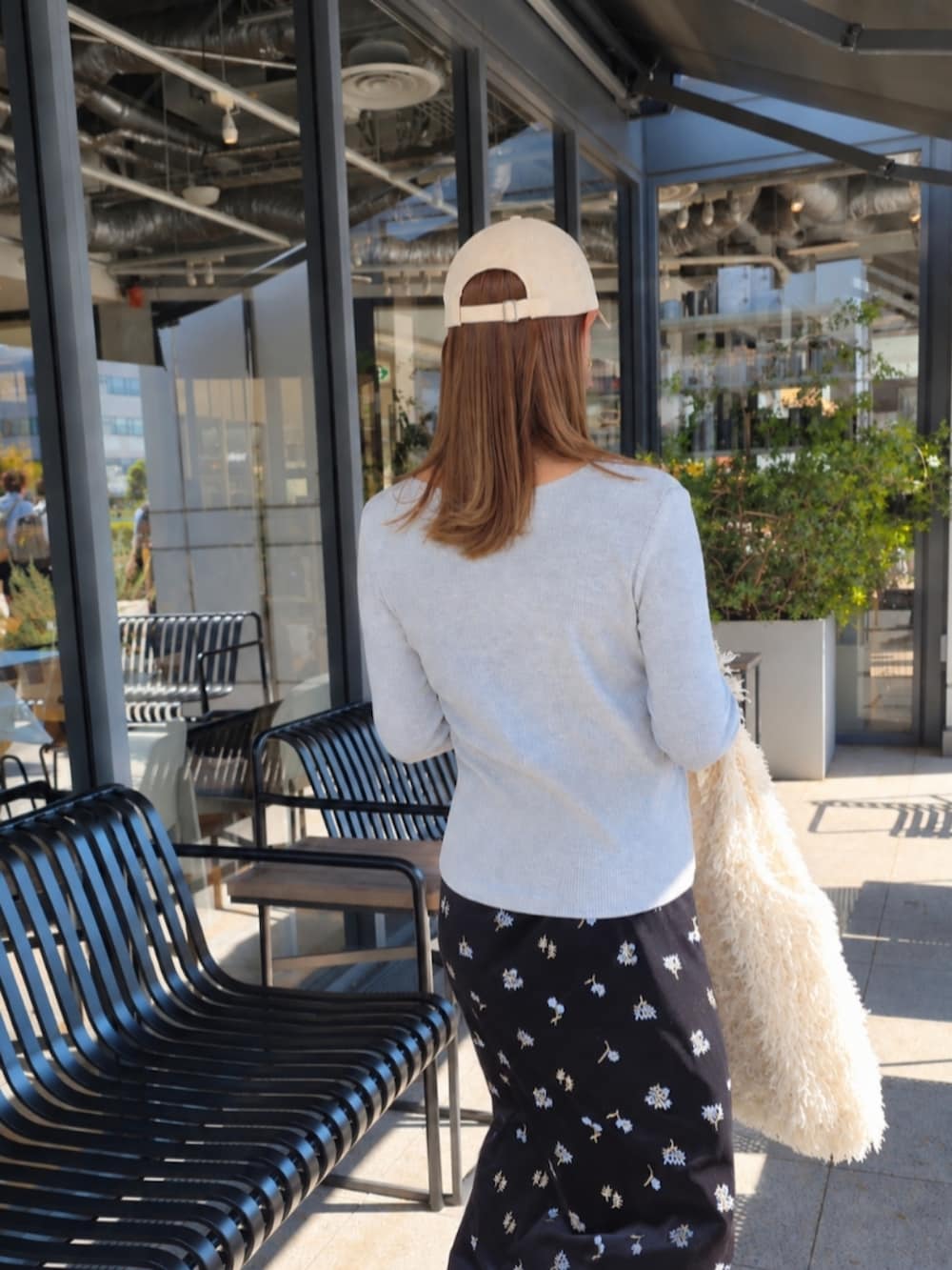 グレー系のカーディガン/ボレロ、ブラック系のスカート、ブラック系のスニーカーを着用したレディースの秋コーディネートの3枚目の写真