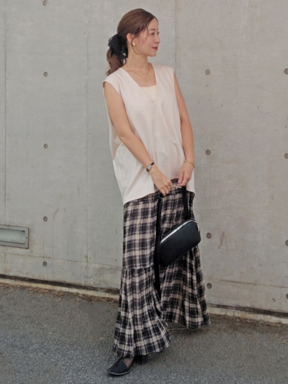 ホワイト系のベスト、ブラック系のスカート、ブラック系のショルダーバッグを着用したレディースの夏コーディネートの2枚目の写真
