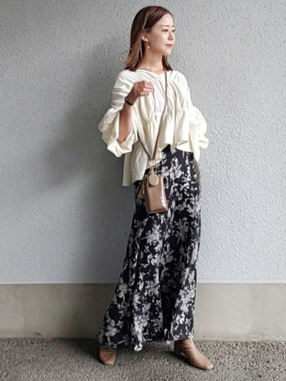 ブラック系のスカート、ホワイト系のシャツ/ブラウス、ベージュ系のブーツを着用したレディースの秋コーディネートの2枚目の写真