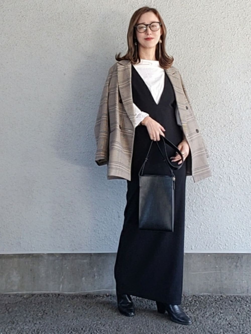 ブラック系のバッグ、ブラック系のワンピース、ブラック系のブーツを着用したレディースの冬コーディネートの2枚目の写真