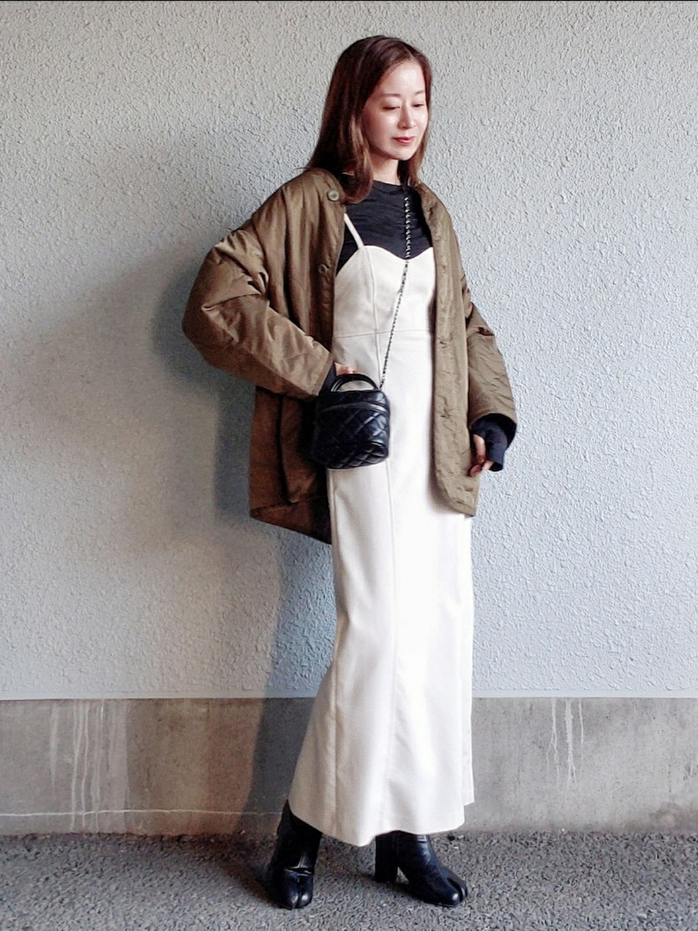 ホワイト系のワンピース、ブラウン系のノーカラージャケット、ブラック系のブーツを着用したレディースの秋コーディネートの2枚目の写真