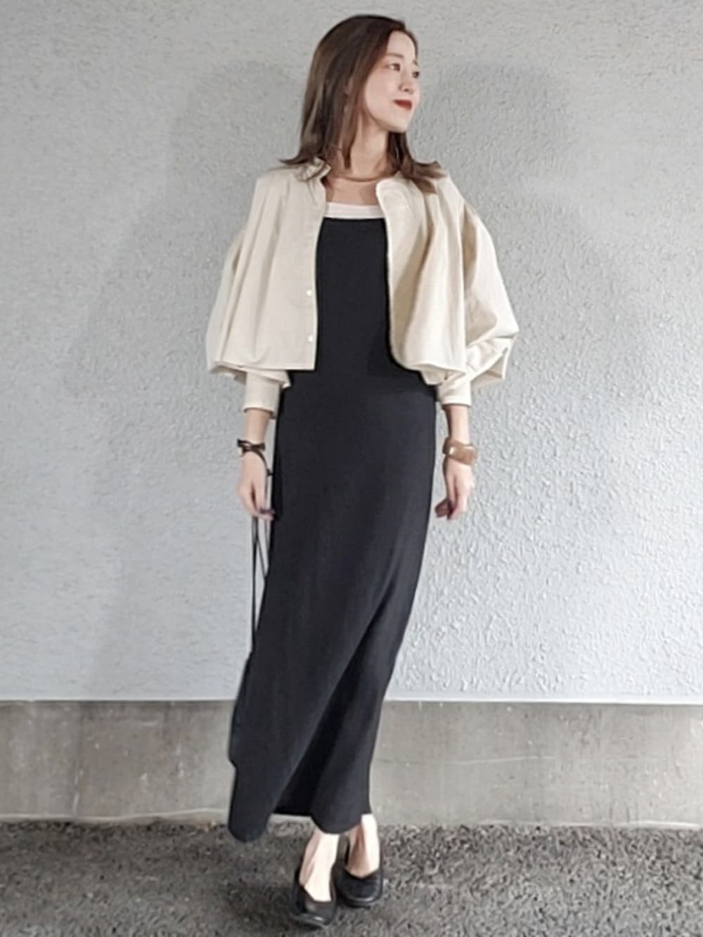 ブラック系のワンピース、ブラック系のハンドバッグ、ホワイト系のシャツ/ブラウスを着用したレディースの春コーディネートの4枚目の写真