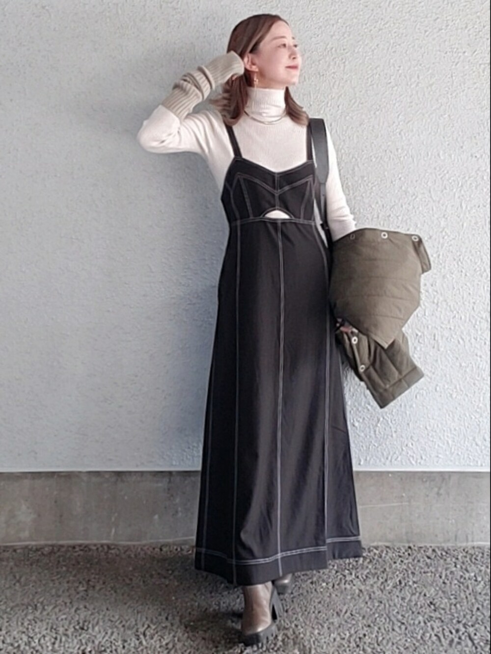 ホワイト系のニット/セーター、グリーン系のダウンベスト、ベージュ系のブーツを着用したレディースの冬コーディネートの3枚目の写真