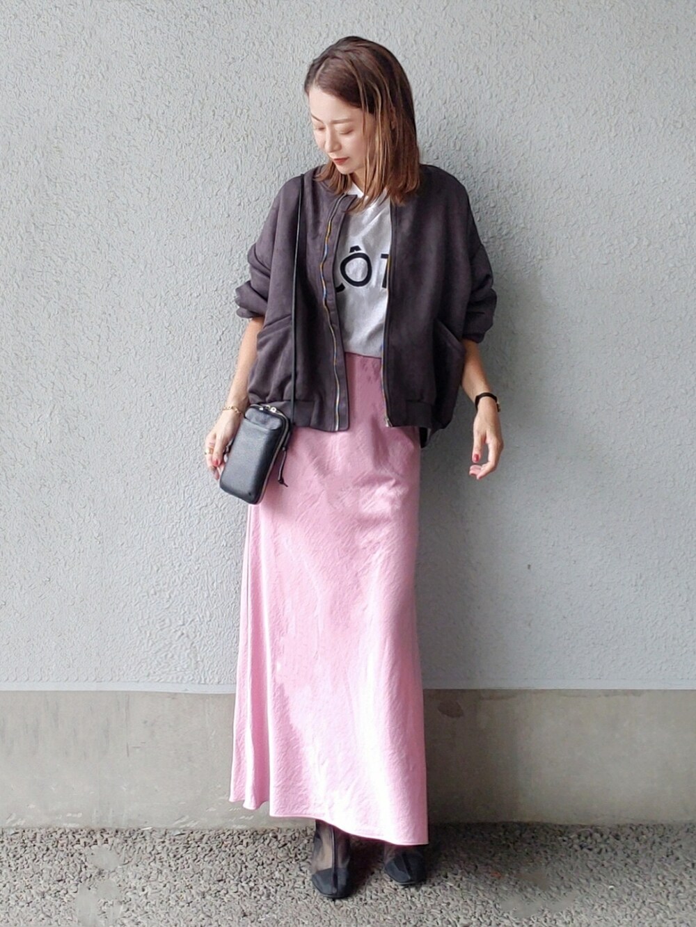 ブラック系のブルゾン、ピンク系のスカート、ブラック系のブーツを着用したレディースの秋コーディネートの2枚目の写真