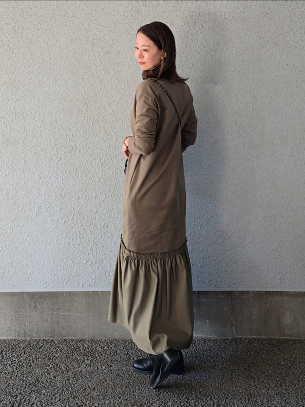 グリーン系のワンピースを着用したレディースの冬コーディネートの3枚目の写真