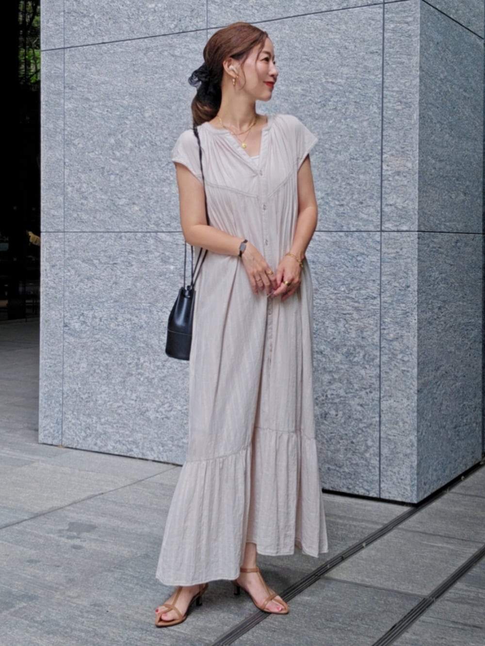 ベージュ系のワンピース、ブラウン系のサンダルを着用したレディースの夏コーディネートの2枚目の写真