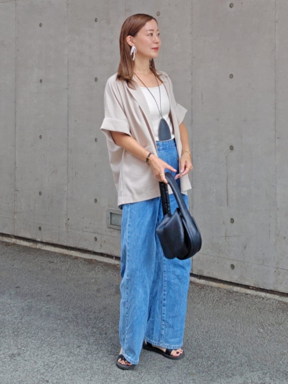 グレー系のシャツ/ブラウス、ブルー系のデニムパンツ、ブラック系のサンダルを着用したレディースの夏コーディネートの4枚目の写真