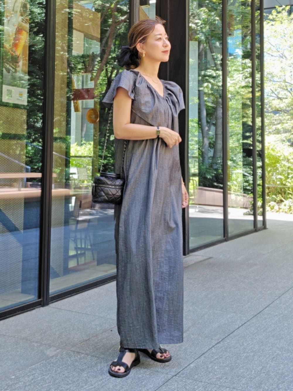 グレー系のワンピース/ドレス、ブラック系のバッグ、ブラック系のサンダルを着用したレディースの夏コーディネートの2枚目の写真