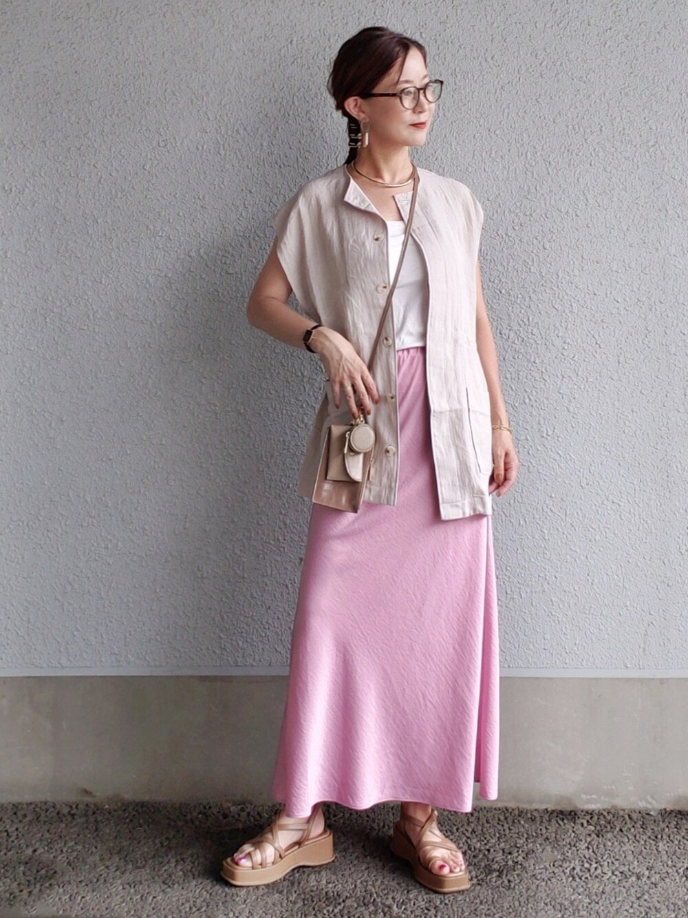 ピンク系のスカート、グレー系のベスト、ブラウン系のサンダルを着用したレディースの夏コーディネートの5枚目の写真