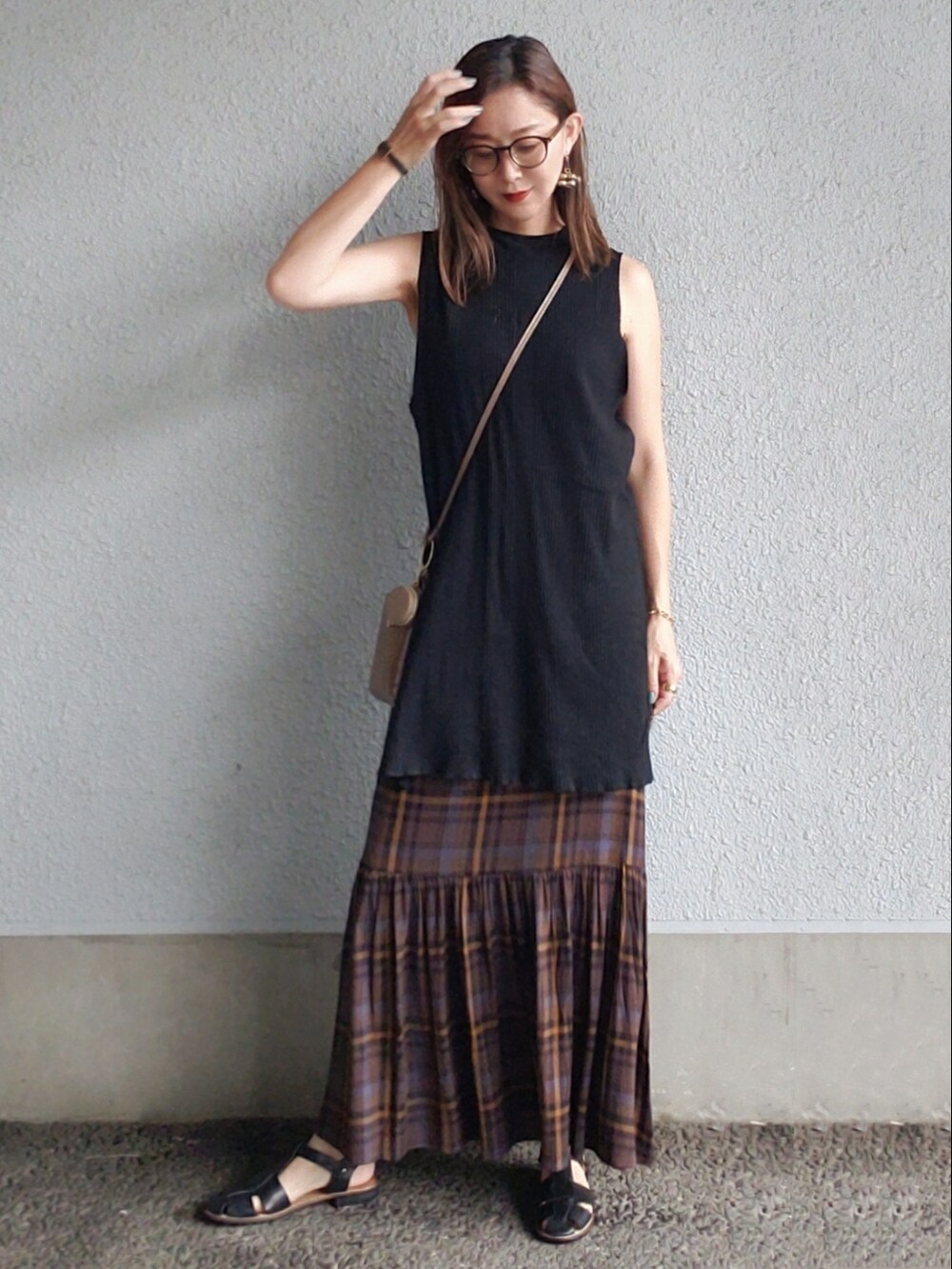 ブラック系のタンクトップ、ブラウン系のスカート、ブラック系のサンダルを着用したレディースの夏コーディネートの2枚目の写真