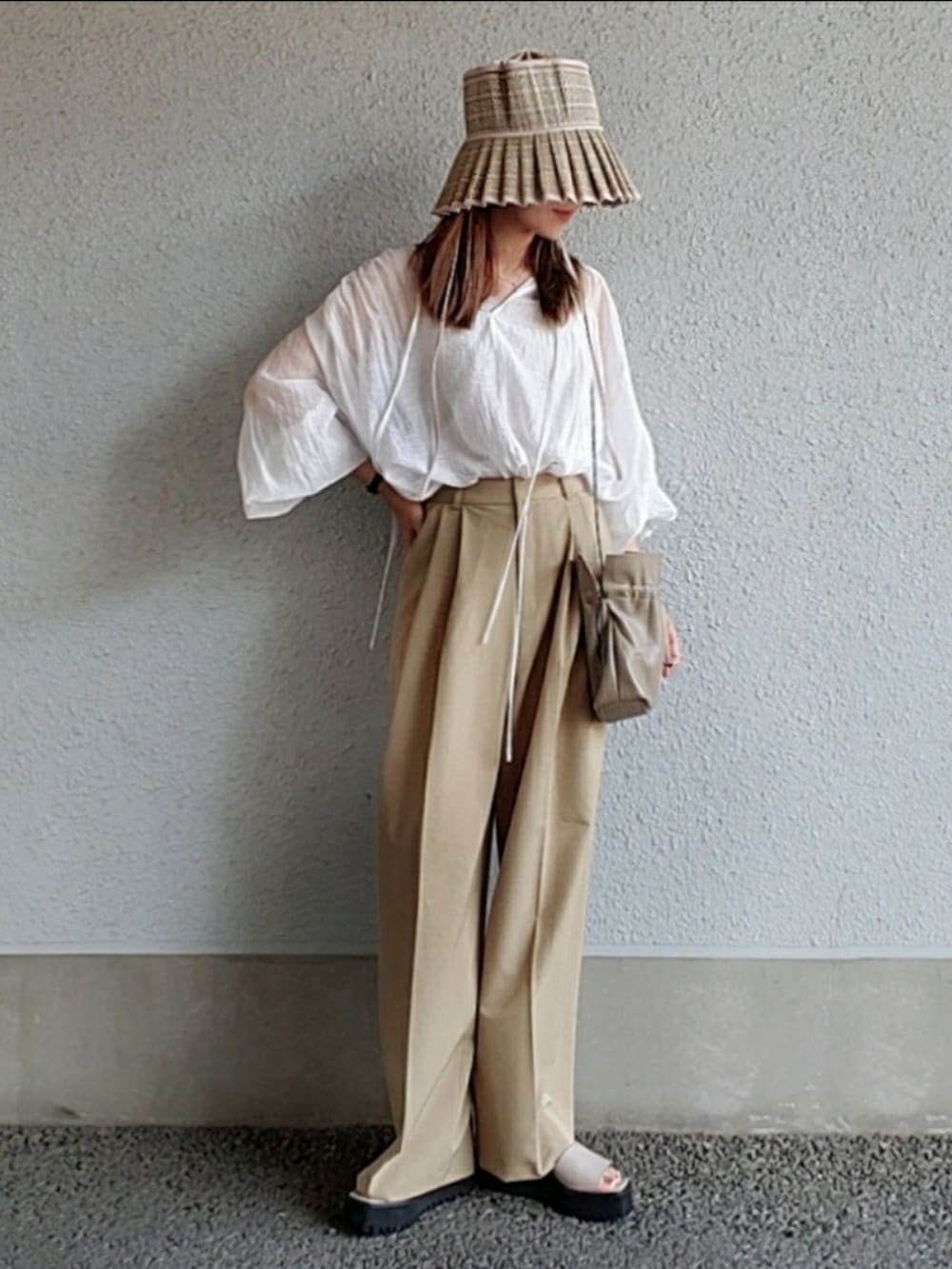 ホワイト系のシャツ/ブラウス、ベージュ系のスラックス、グレー系のサンダルを着用したレディースの春コーディネートの3枚目の写真