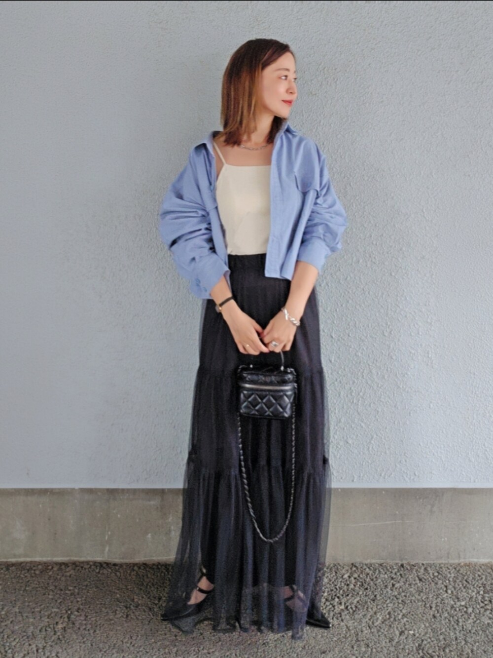 ホワイト系のキャミソール、ブルー系のシャツ/ブラウス、ブラック系のスカートを着用したレディースの春コーディネートの4枚目の写真