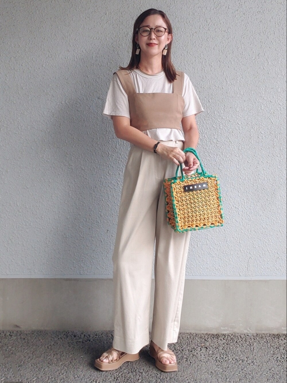 イエロー系のバッグ、ブラウン系のサンダル、グレー系のTシャツ/カットソーを着用したレディースの夏コーディネートの3枚目の写真