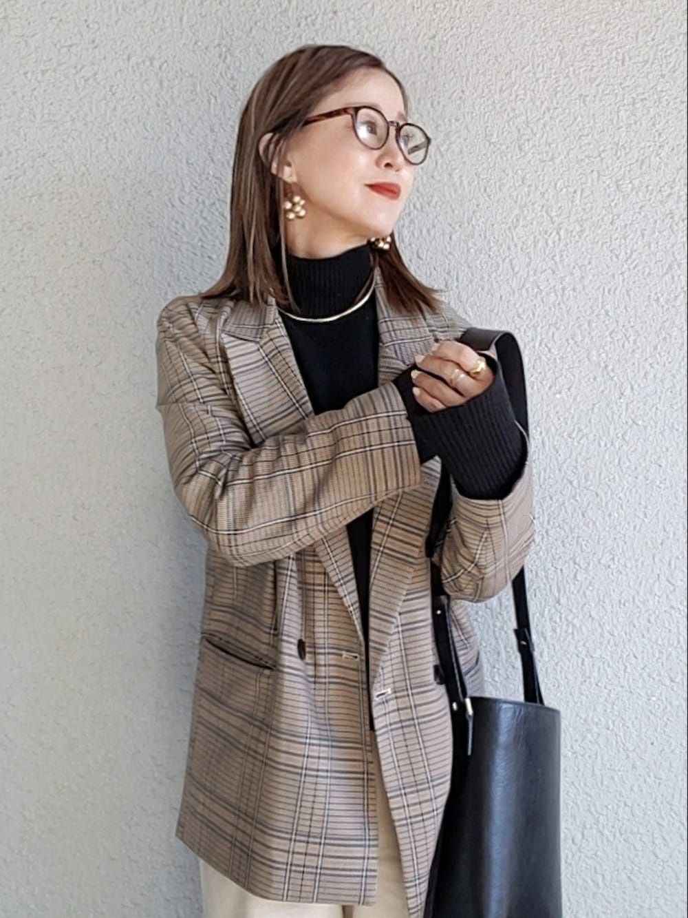 ブルー系のテーラードジャケット、ブラック系のニット/セーター、ベージュ系のその他パンツを着用したレディースの秋コーディネートの3枚目の写真