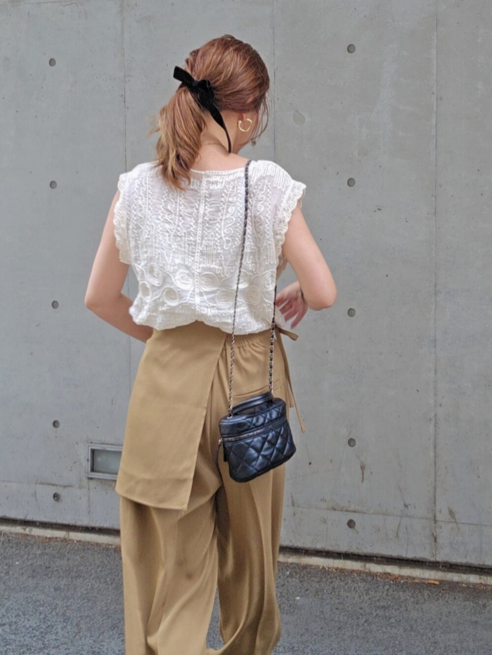 ホワイト系のシャツ/ブラウス、ベージュ系のスラックス、ブラック系のサンダルを着用したレディースの夏コーディネートの3枚目の写真