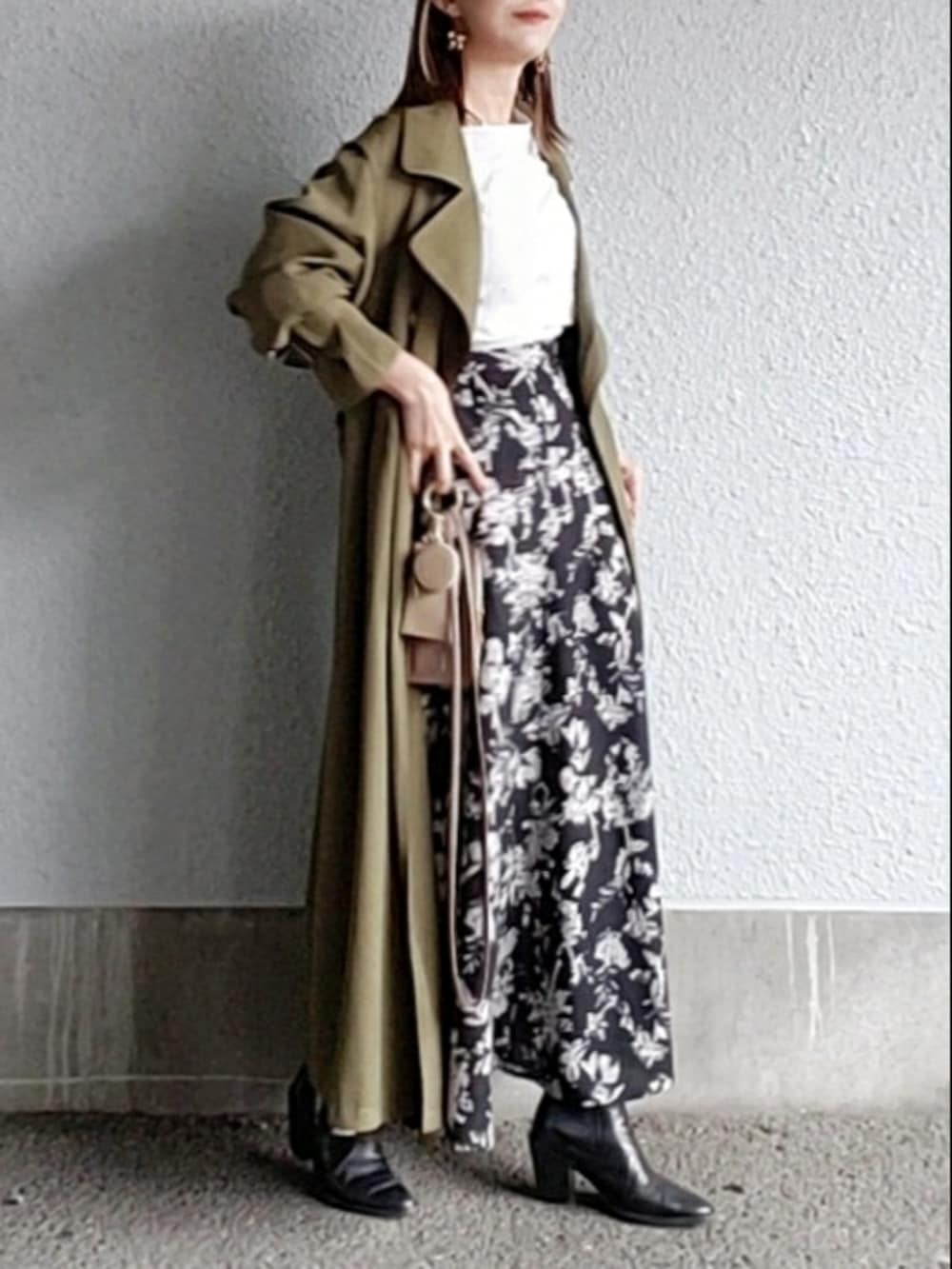 グリーン系のトレンチコート、ブラック系のスカート、ホワイト系のシャツ/ブラウスを着用したレディースの秋コーディネートの4枚目の写真