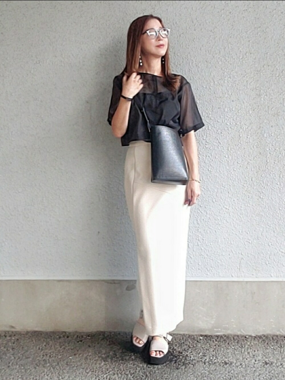 ブラック系のトップス、ベージュ系のスカート、グレー系のサンダルを着用したレディースの夏コーディネートの2枚目の写真