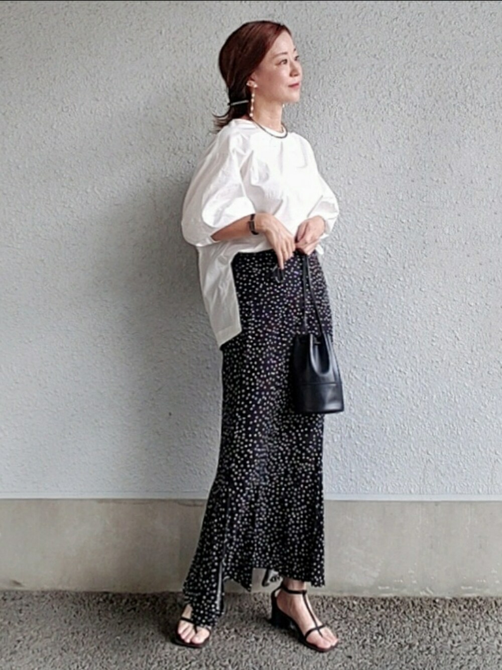 ホワイト系のシャツ/ブラウス、ブラック系のスカート、ブラック系のサンダルを着用したレディースの夏コーディネートの4枚目の写真