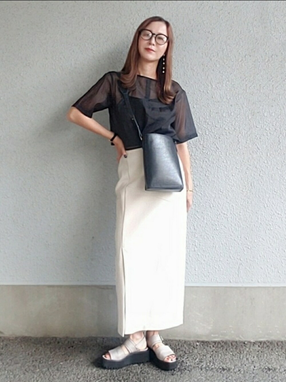 ブラック系のトップス、ベージュ系のスカート、グレー系のサンダルを着用したレディースの夏コーディネートの4枚目の写真