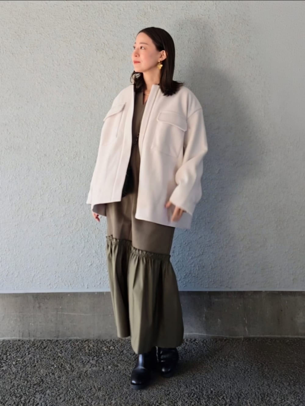 グリーン系のワンピースを着用したレディースの冬コーディネートの4枚目の写真