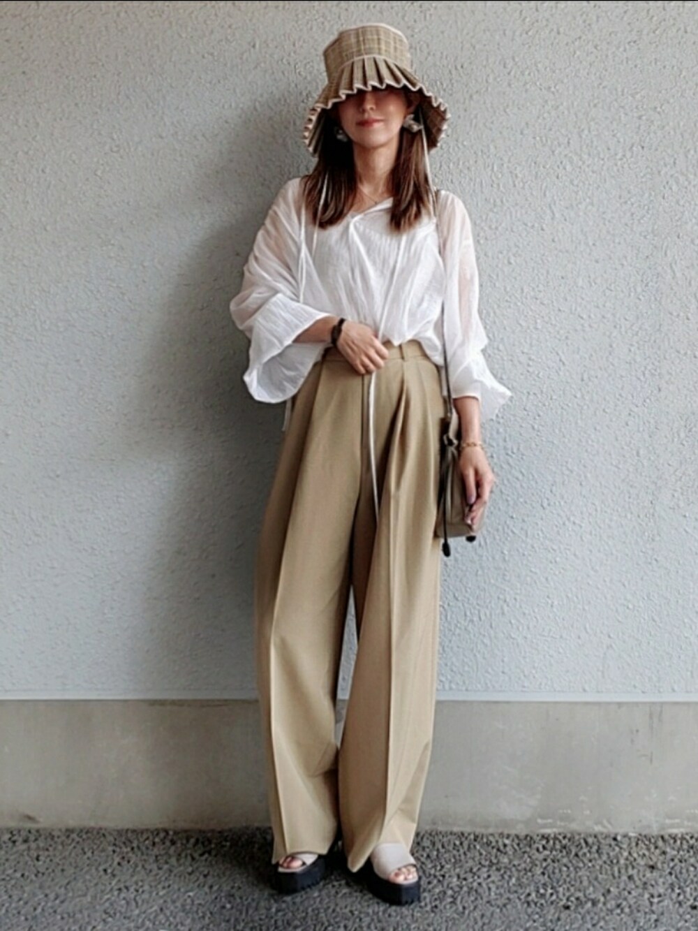 ホワイト系のシャツ/ブラウス、ベージュ系のスラックス、グレー系のサンダルを着用したレディースの春コーディネートの5枚目の写真