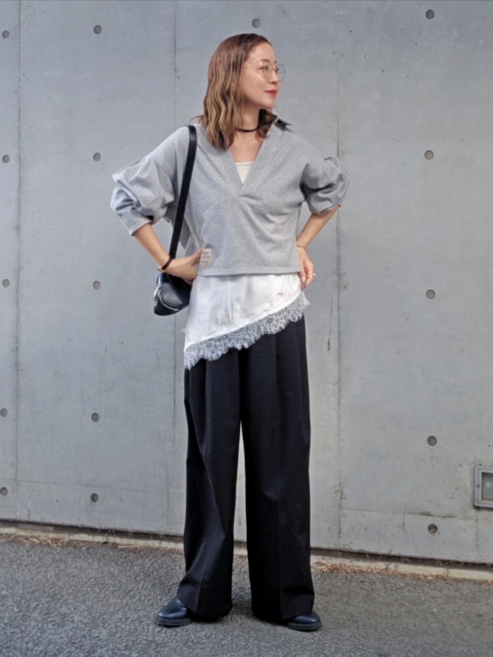 グレー系のスウェット、ブラック系のスラックス、ブラック系のショルダーバッグを着用したレディースの春コーディネートの3枚目の写真