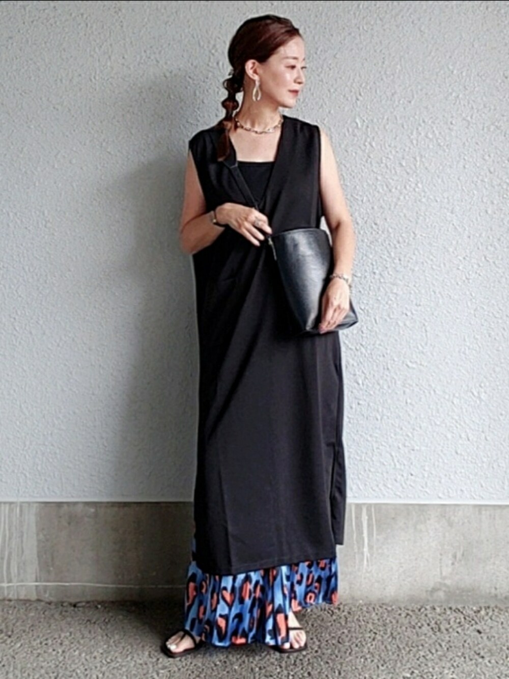 ブラック系のバッグ、ブラック系のワンピース、ブルー系のスカートを着用したレディースの夏コーディネートの2枚目の写真