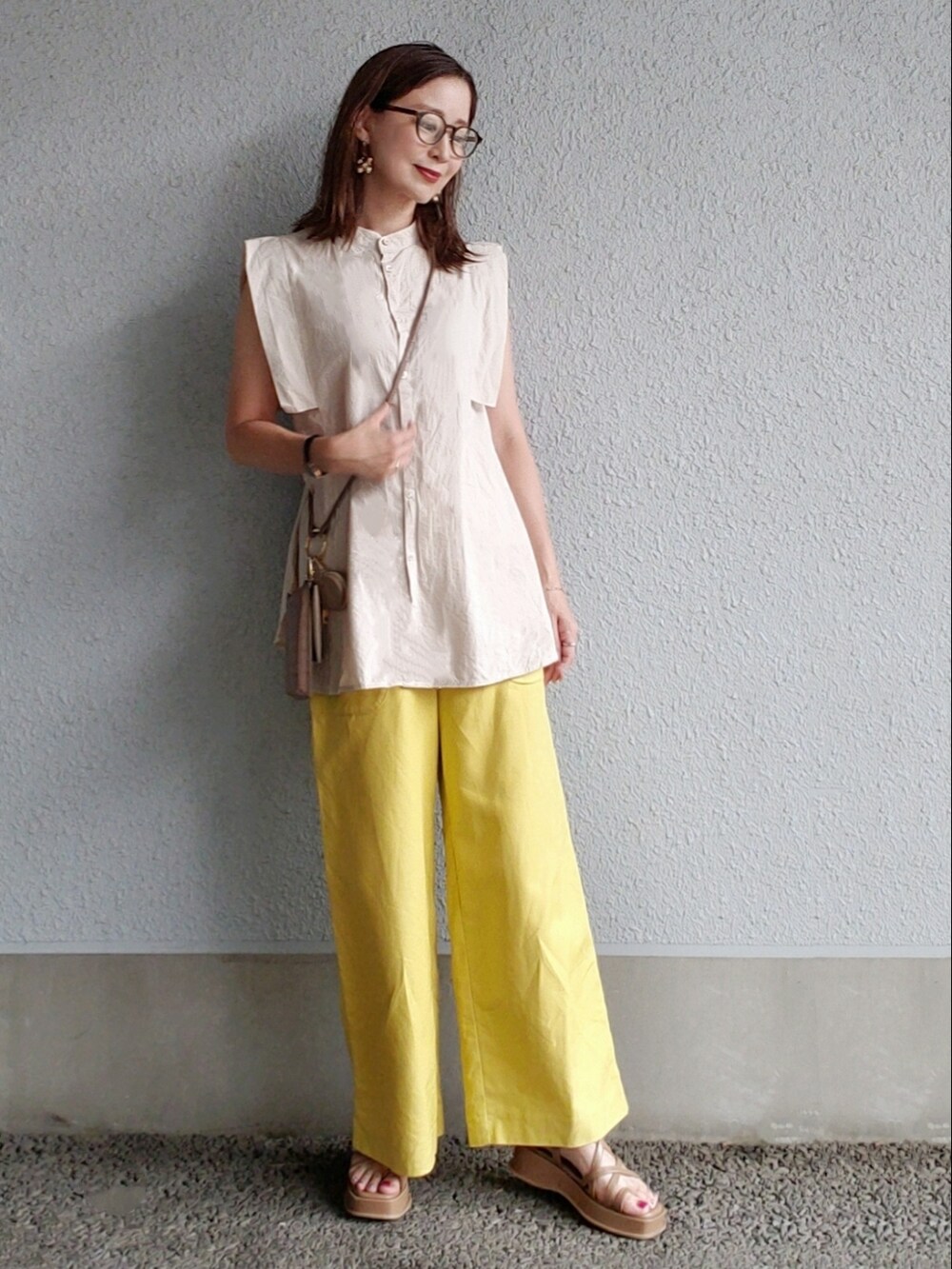 ブラウン系のサンダル、イエロー系のその他パンツ、ブラウン系のショルダーバッグを着用したレディースの夏コーディネートの3枚目の写真