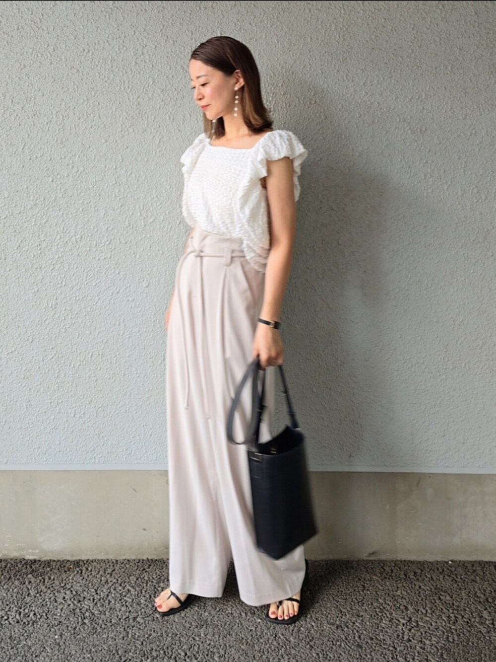 ホワイト系のシャツ/ブラウス、ホワイト系のその他パンツ、ブラック系のサンダルを着用したレディースの夏コーディネートの2枚目の写真