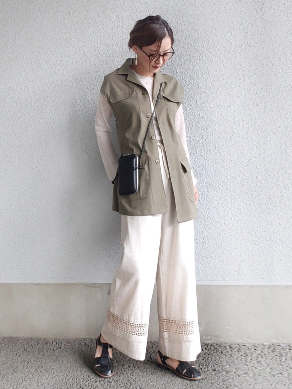 グリーン系のベスト、ベージュ系のその他パンツ、ブラック系のサンダルを着用したレディースの春コーディネートの4枚目の写真