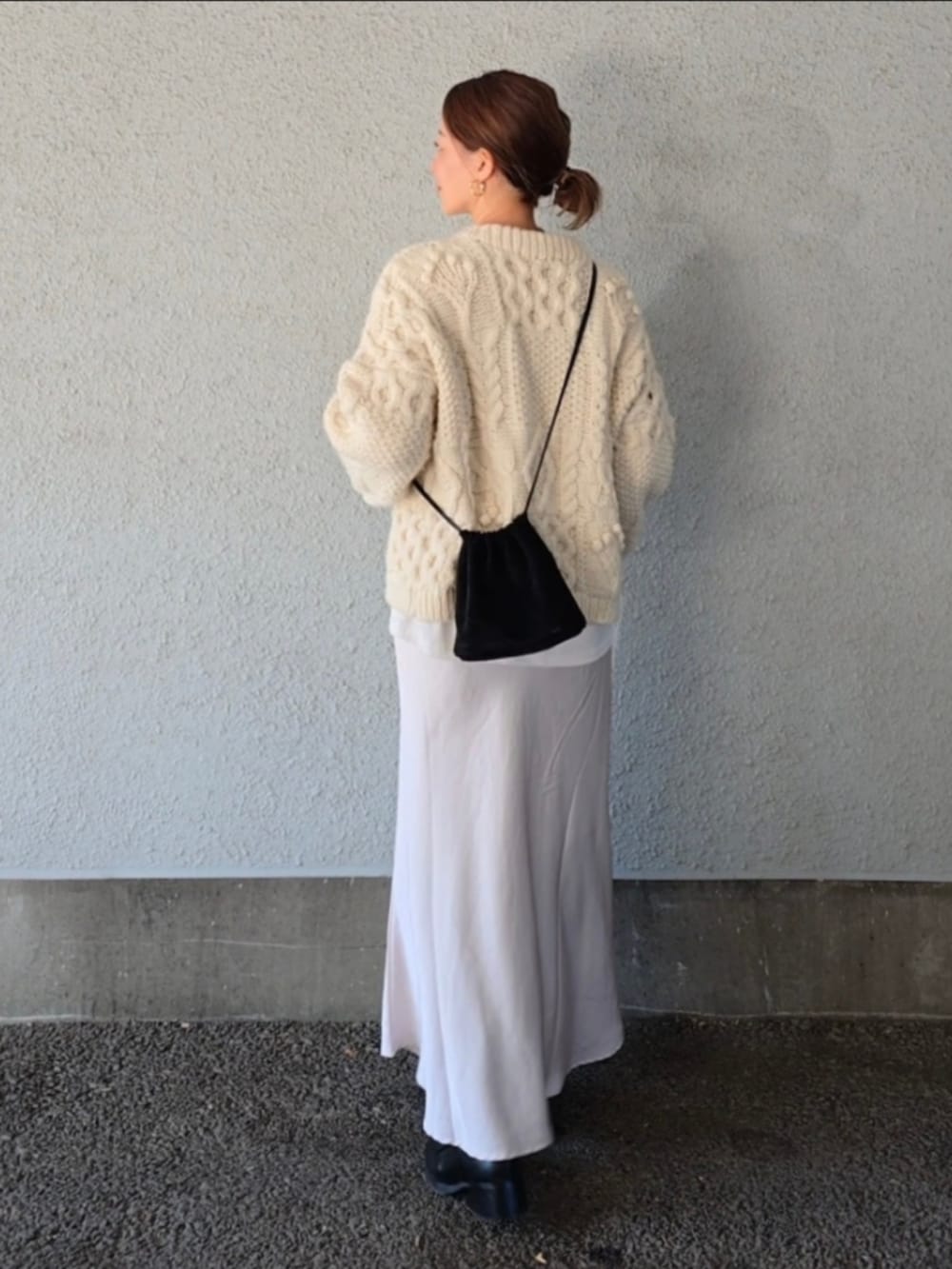 ブラック系のバッグ、ホワイト系のスカート、ホワイト系のニット/セーターを着用したレディースの冬コーディネートの4枚目の写真