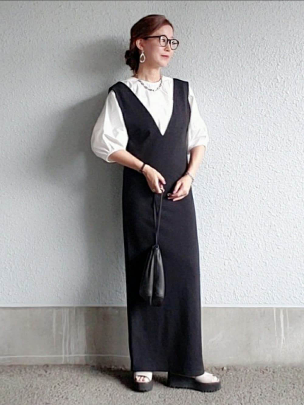 ブラック系のワンピース、グレー系のサンダル、ホワイト系のシャツ/ブラウスを着用したレディースの夏コーディネートの3枚目の写真