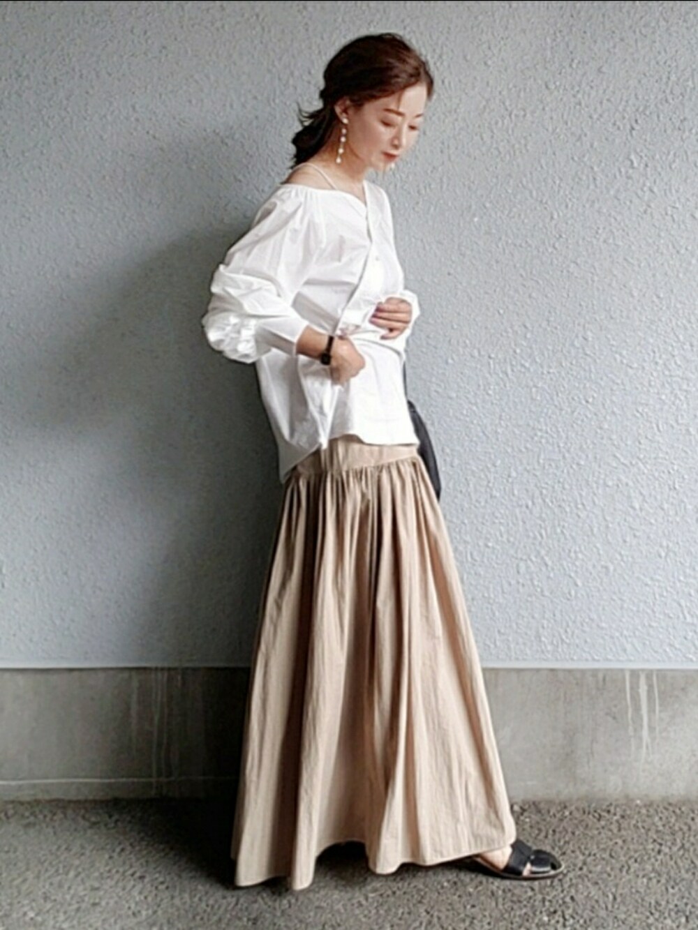 ホワイト系のシャツ/ブラウス、ベージュ系のスカート、ブラック系のバッグを着用したレディースの春コーディネートの3枚目の写真