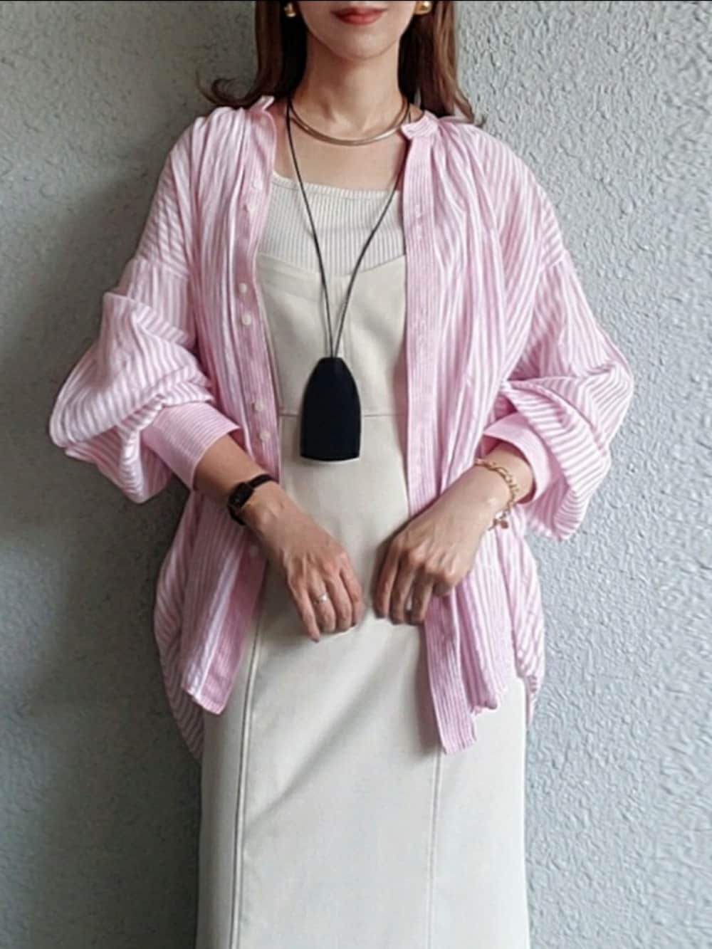 ピンク系のシャツ/ブラウス、ホワイト系のワンピース、ベージュ系のスニーカーを着用したレディースの春コーディネートの2枚目の写真