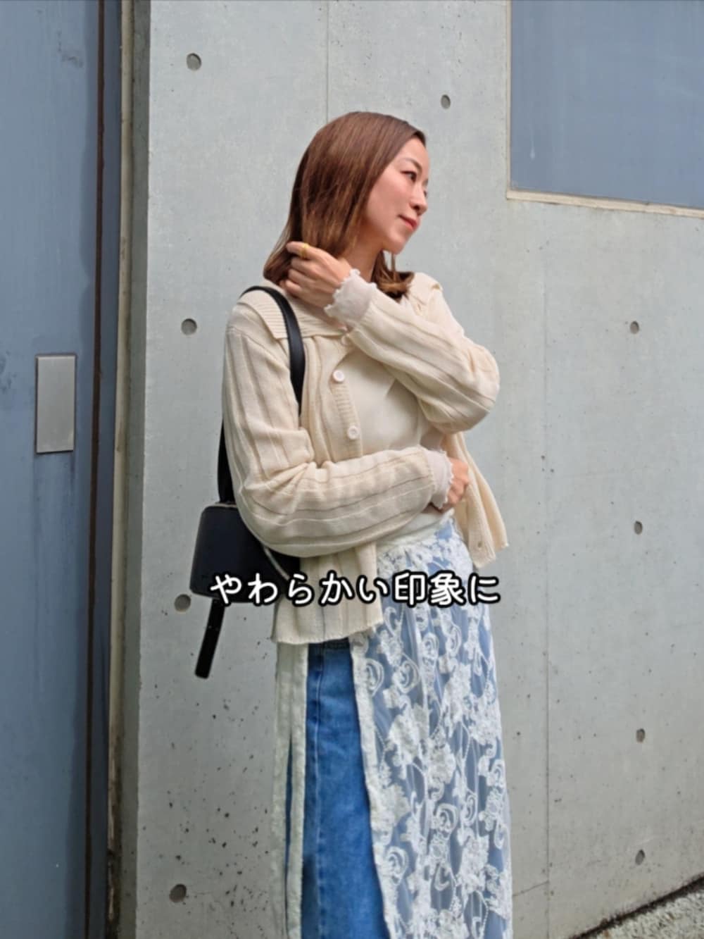 ベージュ系のカーディガン/ボレロ、ホワイト系のスカート、ブルー系のデニムパンツを着用したレディースの春コーディネートの2枚目の写真