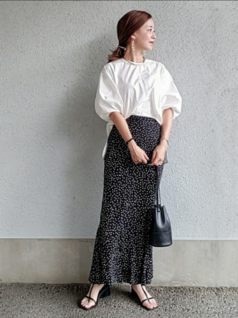 ホワイト系のシャツ/ブラウス、ブラック系のスカート、ブラック系のサンダルを着用したレディースの夏コーディネートの2枚目の写真