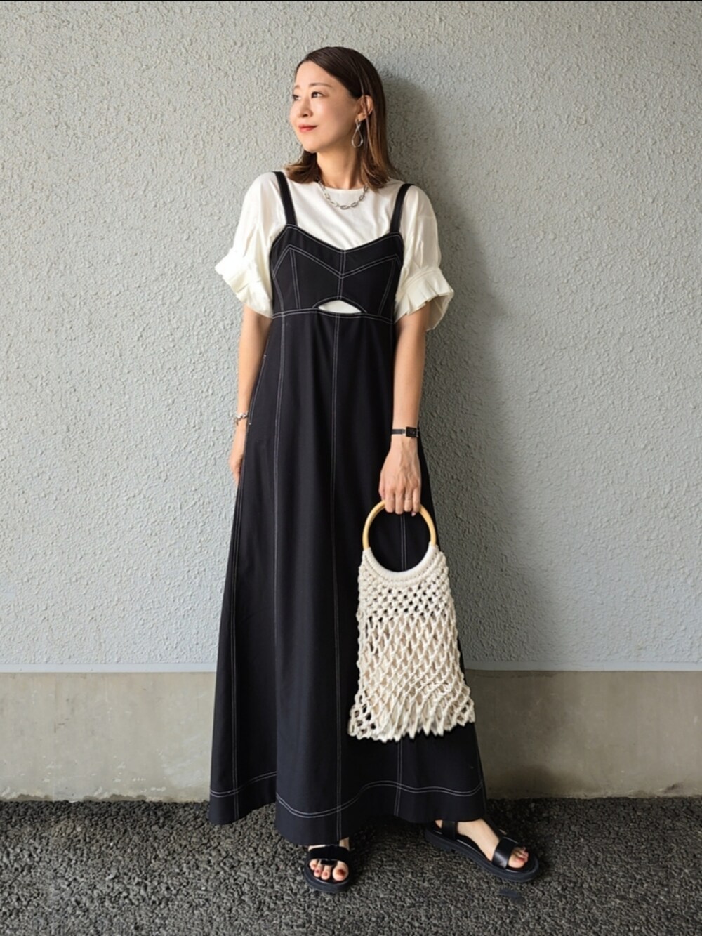 ホワイト系のTシャツ/カットソー、ブラック系のワンピース/ドレス、ブラック系のサンダルを着用したレディースの夏コーディネートの2枚目の写真