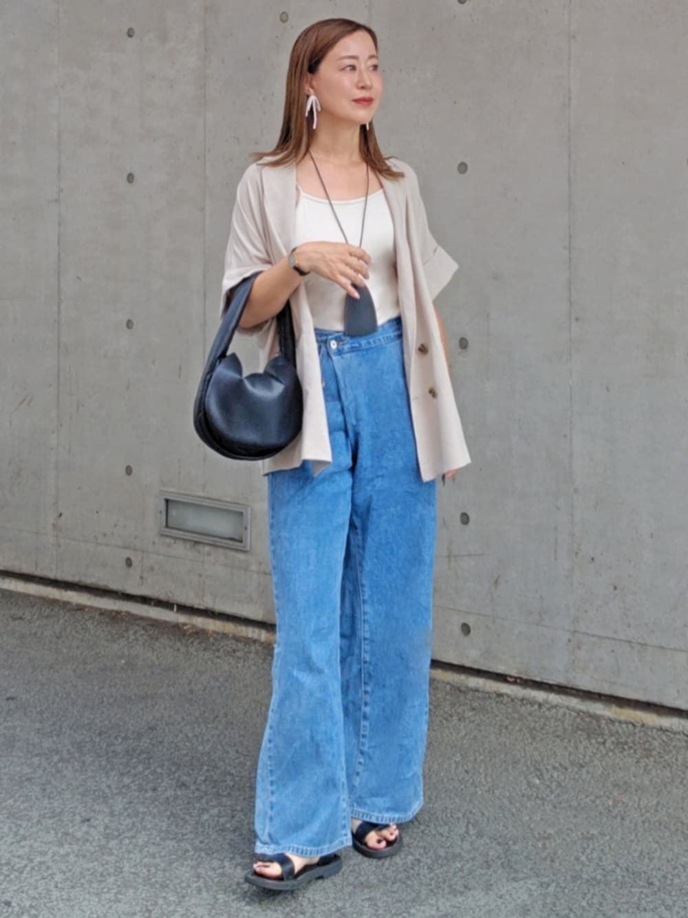 グレー系のシャツ/ブラウス、ブルー系のデニムパンツ、ブラック系のサンダルを着用したレディースの夏コーディネートの3枚目の写真